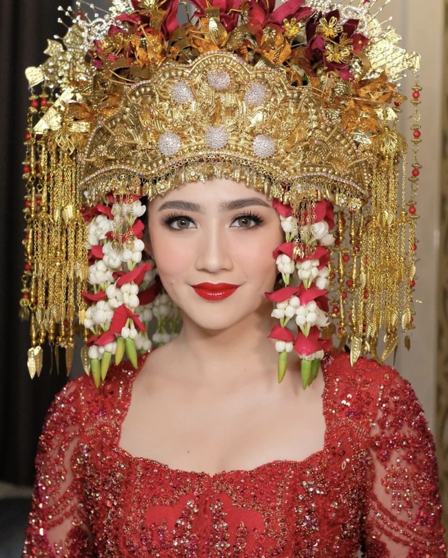 Memiliki darah Palembang, Febby Rastanty menggunakan mahkota yang disebut kesuhan. Tampil dengan nuansa merah dari mulai kebaya hingga makeup look, penampilan glamornya dinilai manglingi. Foto: dok. Instagram @morden.co, dok. Instagram @marlenehariman