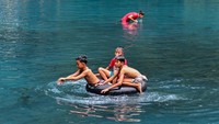 Anak-anak itu tampak asyik bermain air di danau tersebut. 