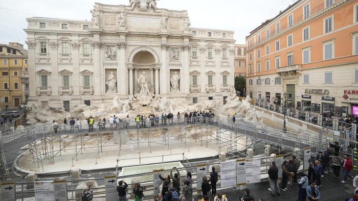 Air Mancur Paling Populer di Roma Surut Imbas Renovasi People walk along an elevated walkway in Rome, Sunday, Nov. 10, 2024 that gives limited access to the Trevi Fountain monument during maintenance work. (AP Photo/Gregorio Borgia)