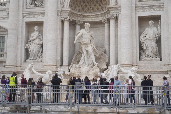 People walk along an elevated walkway in Rome, Sunday, Nov. 10, 2024 that gives limited access to the Trevi Fountain monument during maintenance work. (AP Photo/Gregorio Borgia)