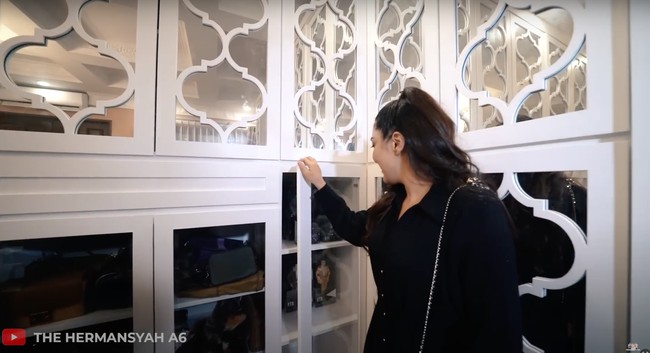 Di dekat ruang kerja mini tersebut juga terdapat lemari-lemari untuk menyimpan barang-barang Anang dan Ashanty. Salah satu lemari kacanya berisi koleksi barang-barang idol K-Pop milik Ashanty. Foto: YouTube/The Hermansyah A6