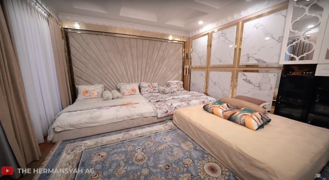 Kamar tidur Anang dan Ashanty tampak memiliki tempat tidur yang luas. Tak hanya itu saja, tempat tidur tersebut juga sengaja dibuat tidak tinggi. Rupanya alasan Anang dan Ashanty memilih tempat tidur tersebut ialah karena cucu-cucunya, agar tetap aman dan nyaman. Foto: YouTube/The Hermansyah A6