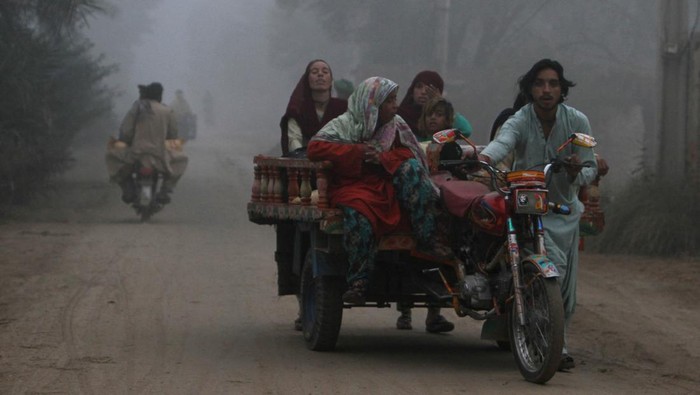 A family moves on a trishaw along a road on a smoggy morning on the outskirts of Multan, Pakistan, November 11, 2024. REUTERS/Quratulain Asim