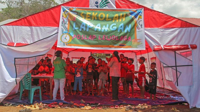 Guru mengajar siswa-siswa SD di sekolah lapangan posko pengungsian warga terdampak erupsi Gunung Lewotobi Laki-laki di Desa Lewolaga, Titehena, Kabupaten Flores Timur, Nusa Tenggara Timur, Senin (11/11/2024). Dinas Pendidikan Kepemudaan dan Olah Raga Flores Timur menggelar sekolah lapangan di sejumlah posko pengungsian terpusat untuk melayani pendidikan bagi siswa-siswa yang menjadi pengungsi selama masa tanggap darurat. ANTARA FOTO/Mega Tokan/app/foc.