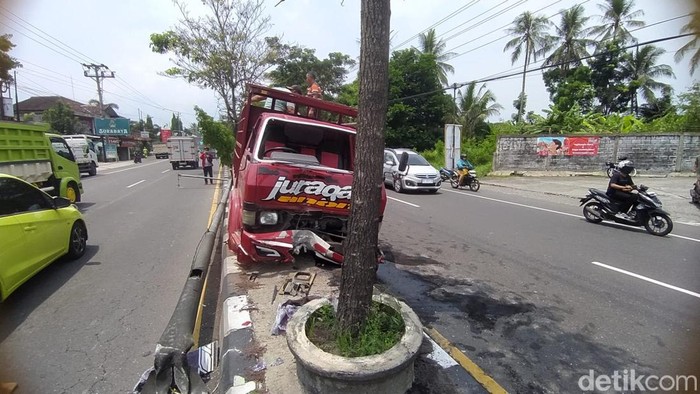 Truk warna merah nyangkut di median jalan usai ditabrak truk warna hijau H 9569 OV di Japunan, Mertoyudan, Kabupaten Magelang, Senin (11/11/2024).