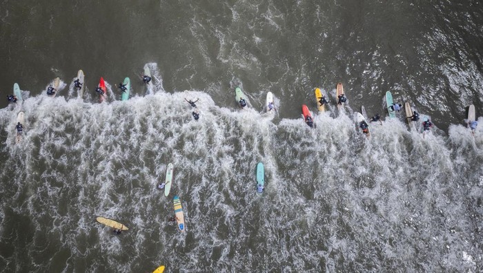 Aksi Ratusan Lansia di Brasil Berselancar Pecahkan Rekor Dunia A drone picture of surfers trying to ride the same wave to break the Guinness World Record, in Santos, Brazil November 10, 2024. REUTERS/Tuane Fernandes TPX IMAGES OF THE DAY