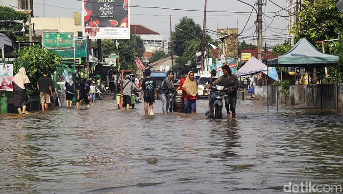 Warga beraktivitas di tengah banjir yang merendam Jurangmangu Barat, Pondok Aren, Tangerang Selatan, Banten, Selasa (12/11/2024). Selain akibat hujan deras pada Senin (11/11/2024) sore, banjir disebabkan oleh jebolnya tanggul sungai yang sedang dalam perbaikan.