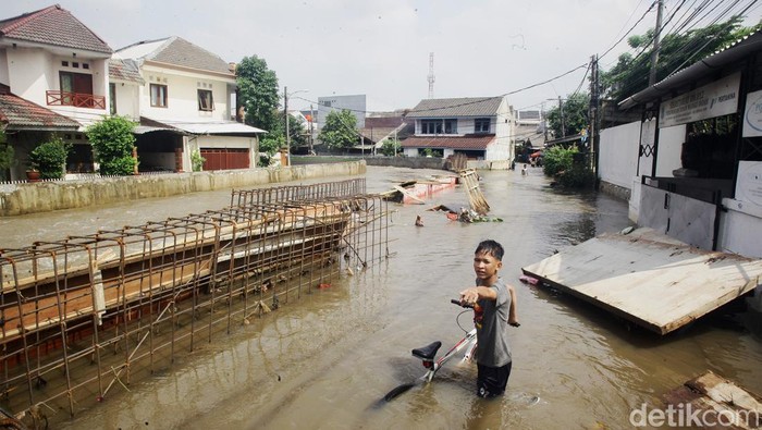 Warga beraktivitas di tengah banjir yang merendam Jurangmangu Barat, Pondok Aren, Tangerang Selatan, Banten, Selasa (12/11/2024). Selain akibat hujan deras pada Senin (11/11/2024) sore, banjir disebabkan oleh jebolnya tanggul sungai yang sedang dalam perbaikan.