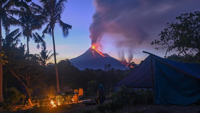 Lava pijar dan kolom asap yang keluar dari kawah Gunung Lewotobi Laki-laki tampak dari lokasi pengungsian swadaya di perbukitan Desa Pululera, Wulanggitang, Kabupaten Flores Timur, Nusa Tenggara Timur, Senin (11/11/2024) malam. Pusat Vulkanologi dan Mitigasi Bencana Geologi (PVMBG) Badan Geologi Kementerian Energi dan Sumber Daya Mineral (ESDM) melaporkan hingga Selasa (13/11) pagi Gunung Lewotobi Laki-laki masih mengalami erupsi dengan ketinggian kolom abu setinggi 3.500-4.000 meter dan terus mengeluarkan lava ke arah barat laut. ANTARA FOTO/Aditya Pradana Putra/Spt.