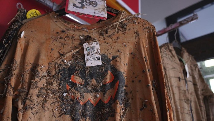 Mud covered clothes are displayed in a store after floods in Catarroja that left hundreds dead or missing in the Valencia region in Spain, Tuesday, Nov. 12, 2024. (AP Photo/Alberto Saiz)