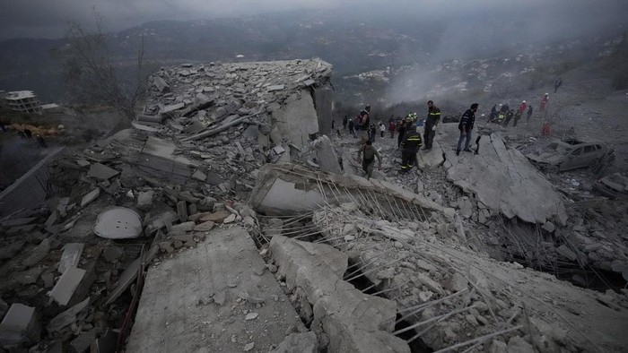 Rescue workers search for victims as smoke rises from a destroyed house hit in an Israeli airstrike in Baalchmay village east of Beirut, Lebanon, Tuesday, Nov. 12, 2024. (AP Photo/Hassan Ammar)