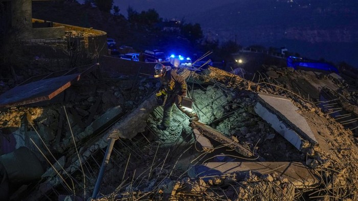 Rescue workers search for victims as smoke rises from a destroyed house hit in an Israeli airstrike in Baalchmay village east of Beirut, Lebanon, Tuesday, Nov. 12, 2024. (AP Photo/Hassan Ammar)