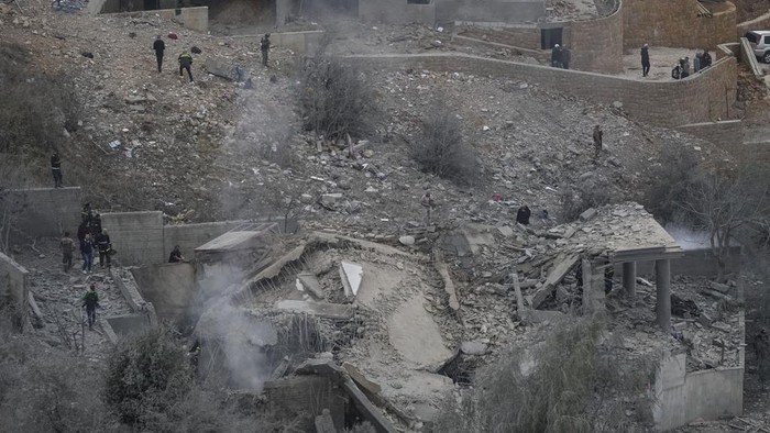 Rescue workers search for victims as smoke rises from a destroyed house hit in an Israeli airstrike in Baalchmay village east of Beirut, Lebanon, Tuesday, Nov. 12, 2024. (AP Photo/Hassan Ammar)