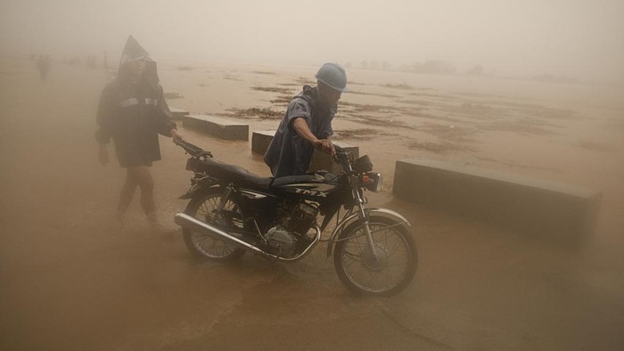 A resident wades through a flooded street caused by heavy rains from typhoon Toraji in Ilagan City, Isabela province, northern Philippines on Tuesday, Nov. 12, 2024. (AP Photo/Noel Celis)