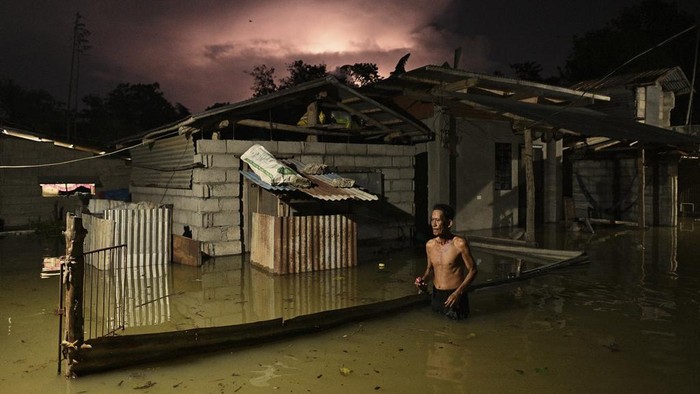 A resident wades through a flooded street caused by heavy rains from typhoon Toraji in Ilagan City, Isabela province, northern Philippines on Tuesday, Nov. 12, 2024. (AP Photo/Noel Celis)