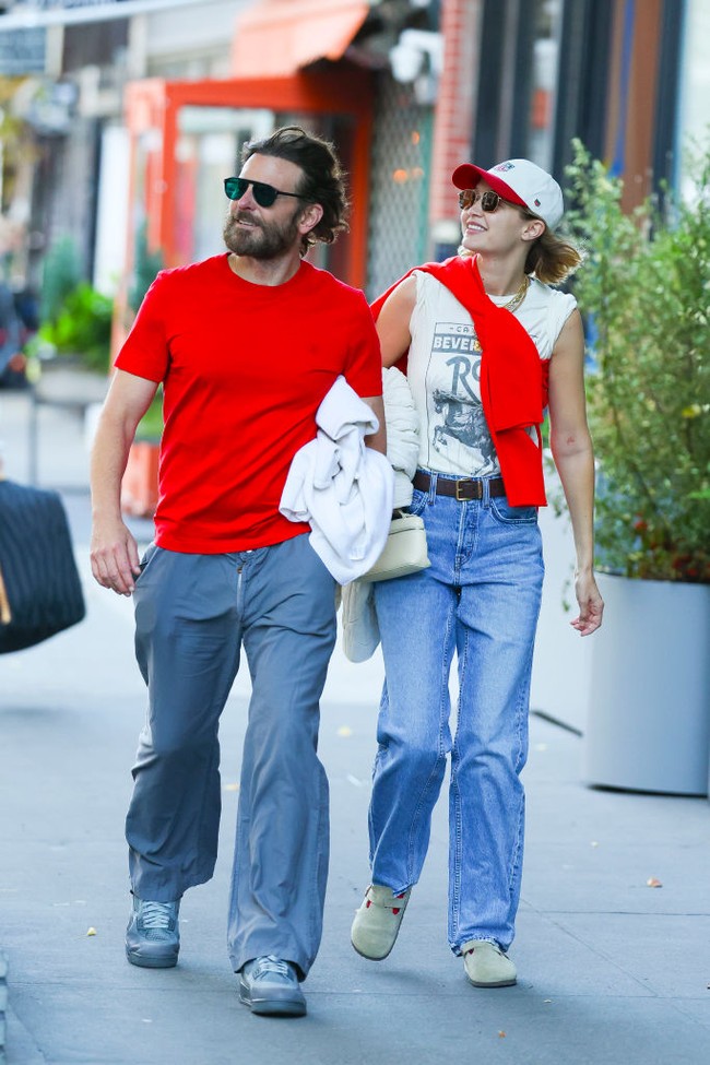 Bradley Cooper juga tampak membawa jaket putih yang digenggamnya di bawah lengan.Untuk pilihan sepatu, keduanya sama-sama memakai sneakers. Foto: Getty Images