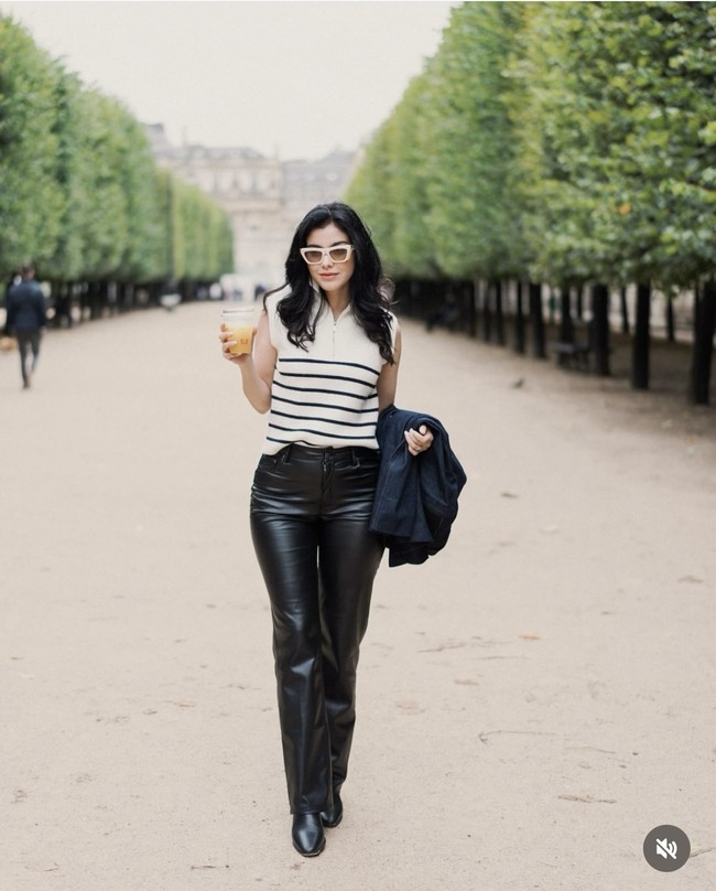 Memadukan atasan garis-garis tanpa lengan dengan celana panjang hitam berbahan latex membuat penampilan Medina terlihat simpel namun tetap stylish. Penampilannya itu kemudian dilengkapi dengan kaca mata hitam berframe krem. Foto: Instagram/@medinadinaaa