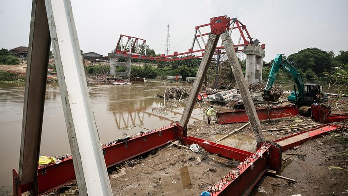 Pekerja mengangkat rangka besi proyek pembangunan Jembatan Butuh yang diterjang arus air sungai Bengawan Solo di Masaran, Sragen, Jawa Tengah, Rabu (13/4/2024). Konstruksi proyek pembangunan jembatan yang menghubungkan Kecamatan Plupuh dengan Masaran Sragen dengan anggaran Rp 14,4 miliar tersebut nyaris rubuh akibat diterjang kuatnya arus sungai Bengawan Solo. ANTARA FOTO/Mohammad Ayudha/YU