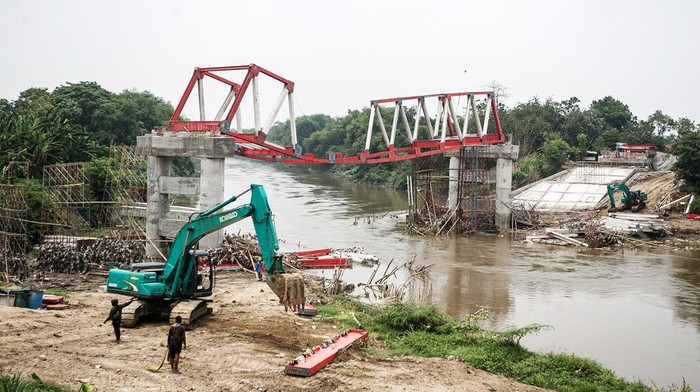 Pekerja mengangkat rangka besi proyek pembangunan Jembatan Butuh yang diterjang arus air sungai Bengawan Solo di Masaran, Sragen, Jawa Tengah, Rabu (13/4/2024). Konstruksi proyek pembangunan jembatan yang menghubungkan Kecamatan Plupuh dengan Masaran Sragen dengan anggaran Rp 14,4 miliar tersebut nyaris rubuh akibat diterjang kuatnya arus sungai Bengawan Solo. ANTARA FOTO/Mohammad Ayudha/YU