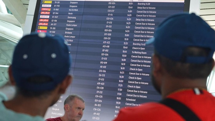 Calon penumpang pesawat melihat informasi jadwal keberangkatan pesawat di Terminal Internasional Bandara Internasional I Gusti Ngurah Rai, Badung, Bali, Rabu (13/11/2024). Pengelola bandara tersebut mencatat pada Rabu (13/11) hingga pukul 13.00 Wita terdapat 90 penerbangan domestik serta internasional yang seharusnya berangkat dan tiba di Bandara Bali dibatalkan akibat dampak erupsi Gunung Lewotobi Laki-Laki di Kabupaten Flores Timur, Nusa Tenggara Timur. ANTARA FOTO/Fikri Yusuf/YU