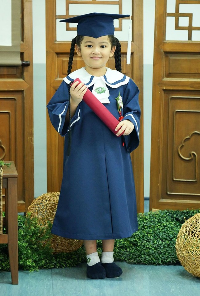 Tampil menggemaskan , Thania tampak mengenakan pakaian berwarna biru lengkap dengan toga di kepalanya. Rambut panjangnya tampak dikepang dua. Foto: Instagram/@ruben_onsu