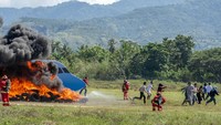 Sejumlah penumpang berusaha menyelamatkan diri saat pesawat yang ditumpangi terbakar dalam simulasi penanggulangan keadaan darurat di Bandara Mutiara Sis Aljufri Palu, Sulawesi Tengah, Kamis (14/11/2024).