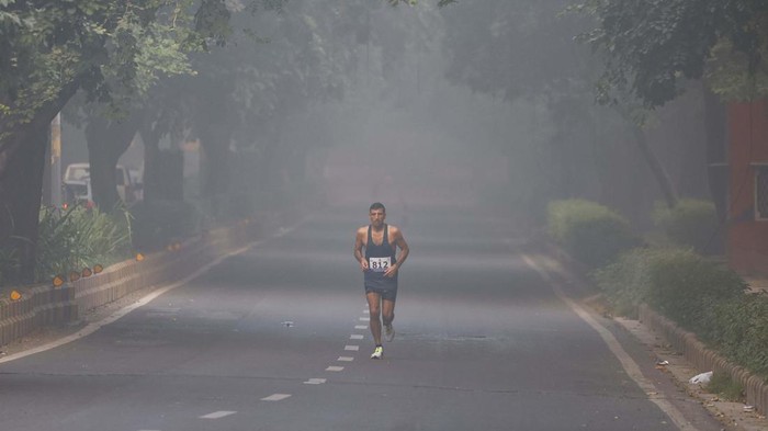 A man jogs as he participates in a marathon while the sky is enveloped with smog after Delhi’s air quality was classified as 