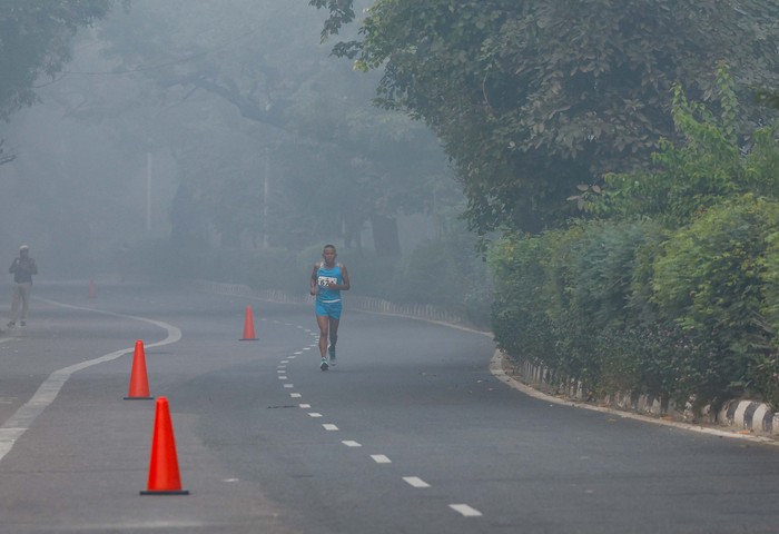 A man jogs as he participates in a marathon while the sky is enveloped with smog after Delhi’s air quality was classified as 