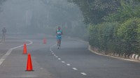 Seorang pria berlari saat mengikuti marathon saat langit diselimuti kabut asap di New Delhi, India, Kamis (14/11). 