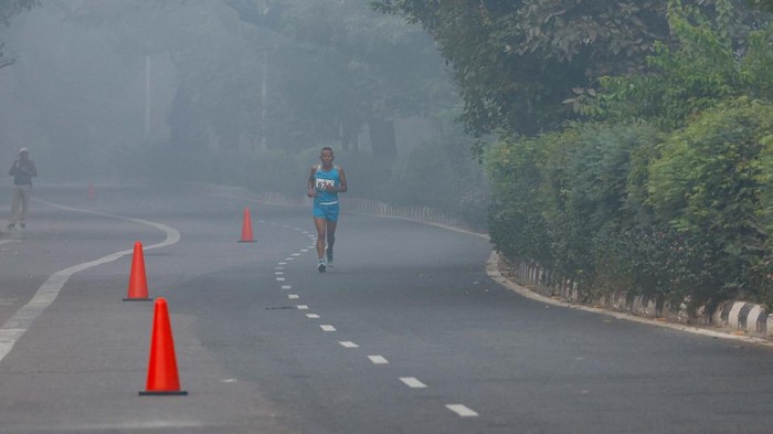 A man jogs as he participates in a marathon while the sky is enveloped with smog after Delhi’s air quality was classified as 
