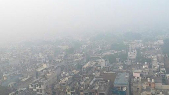 An aerial view shows houses engulfed in smog in New Delhi on November 14, 2024. Residents of Indias capital New Delhi choked in a blanketing toxic smog on November 13 as worsening air pollution surged past 50 times the World Health Organizations recommended daily maximum. (Photo by SAJJAD HUSSAIN / AFP)
