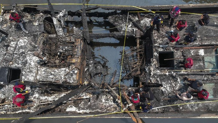 Foto udara petugas Inafis Polda Jateng mengumpulkan barang bukti dari kapal yang terbakar di Panjang Wetan, Kota Pekalongan, Jawa Tengah, Rabu  (13/11/2024). Petugas Inafis Polda Jateng dan Polres Pekalongan Kota masih mengumpulkan barang bukti bagian-bagian penyebab kebakaran 11 kapal untuk kemudian dilakukan uji laboratoium forensik. ANTARA FOTO/Harviyan Perdana Putra/YU