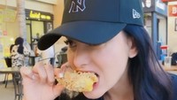 Medina terlihat lahap menyantap chicken wings. Ia mencocolnya ke saus keju. Foto: Instagram medinadinaaa