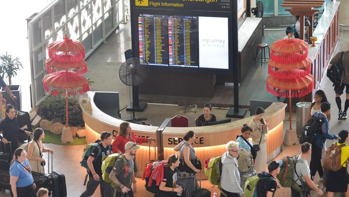 Calon penumpang pesawat melihat informasi jadwal keberangkatan di area Terminal Internasional Bandara Internasional I Gusti Ngurah Rai, Badung, Bali, Kamis (14/11/2024). Bandara Bali tetap beroperasi secara normal meskipun terdapat sejumlah maskapai yang memutuskan melakukan pembatalan penerbangan dengan pertimbangan keamanan dan keselamatan terkait dengan erupsi Gunung Lewotobi Laki-Laki di Kabupaten Flores Timur, Nusa Tenggara Timur. ANTARA FOTO/Fikri Yusuf/rwa.