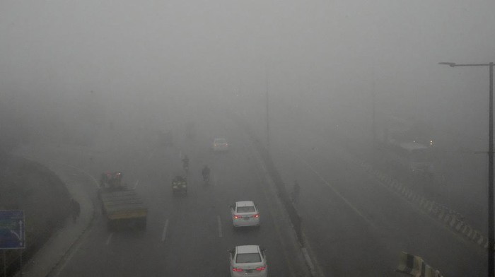 A cyclist crosses a road as smog envelopes the area of Lahore, Pakistan, Thursday, Nov. 14, 2024. (AP Photo/K.M. Chaudary)