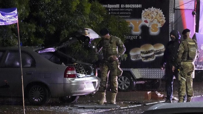 Personel kepolisian Brasil memeriksa mobil yang menjadi salah satu sumber ledakan di luar gedung Mahkamah Agung pada Rabu (13/11) malam. (AP Photo/Eraldo Peres)