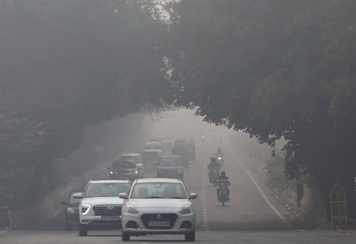 Traffic passes by on a road as the sky is enveloped with smog after Delhis air quality was classified as 