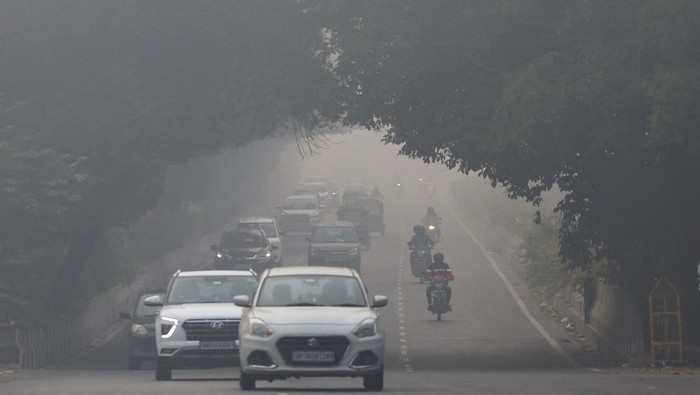 Traffic passes by on a road as the sky is enveloped with smog after Delhis air quality was classified as 