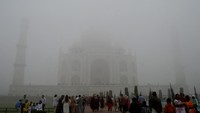 Pengunjung melihat ke arah Taj Mahal di tengah polusi udara dan kabut pagi di Agra, India, Kamis (14/11/2024). Kabut asap beracun yang menyelimuti New Delhi memburuk saat suhu menurun.