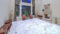 Ruang tamu di rumah ini dilengkapi dengan perapian batu dan lantai dari marmer putih. Jendelanya pun dibuat tinggi dengan sekat beton. Foto: Luxury Homes of Las Vegas via New York Post