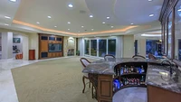 Ruang keluarga di rumah ini bersebelahan dengan bar dan dibuat tanpa sekat. Meja barnya pun dibuat dari kayu dan marmer.