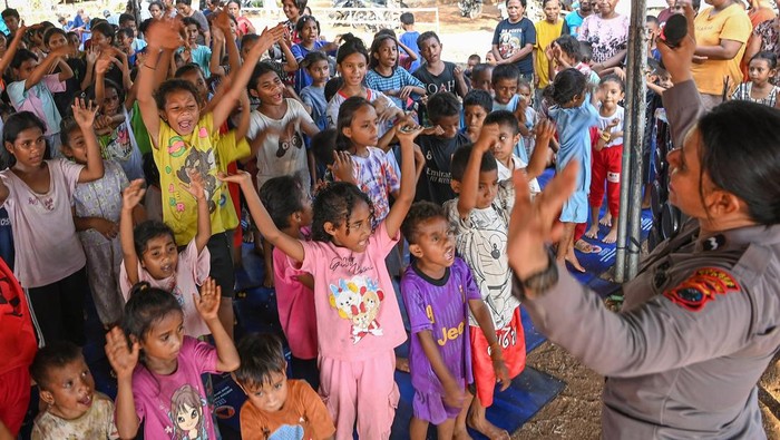 Anggota Polda NTT memandu anak-anak pengungsi erupsi Gunung Lewotobi Laki-laki untuk menari dan bernyanyi dalam layanan trauma healing di posko pengungsian Desa Kobasoma, Titehena, Kabupaten Flores Timur, NTT, Rabu (13/11/2024). Polda NTT memberikan layanan trauma healing untuk membantu anak-anak pengungsi pulih dari dampak psikologis akibat bencana erupsi Lewotobi.