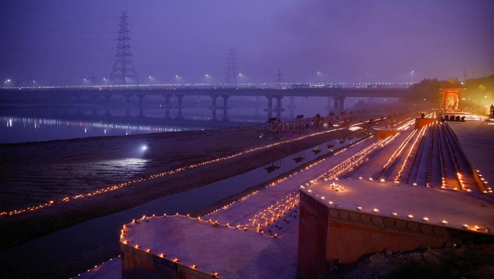 Warga New Delhi Gelar Festival Cahaya di Tengah Kepungan Polusi Tebal A woman lights a diya during Deepotsav celebrations as the sky is enveloped with smog after Delhi's air pollution turned