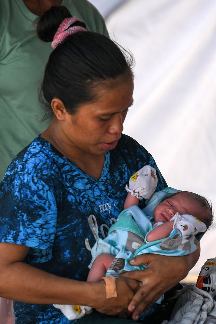 Pasangan pengungsi terdampak erupsi Gunung Lewotobi Laki-laki Paulus Rekatapun (kanan) dan Katarina Kire (tengah) menjaga anak mereka yang baru saja lahir di posko pengungsian Desa Kobasoma, Titehena, Kabupaten Flores Timur, NTT, Rabu (13/11/2024). Di tengah kondisi darurat akibat bencana erupsi Lewotobi mereka merawat putra mereka yang lahir secara normal pada Rabu dini hari. ANTARA FOTO/Aditya Pradana Putra/Spt.