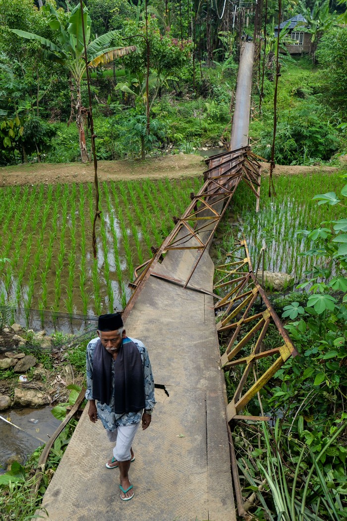 Akses jembatan gantung rusak di Lebak Warga berada di sekitar jembatan Leuwi Awi yang ambruk di Desa Parakanbeusi, Lebak, Banten, Jumat (15/11/2024). Jembatan gantung yang menjadi akses utama penghubung Kecamatan Leuwidamar-Bojongmanik tersebut ambruk pada Kamis (14/11/2024) diduga akibat rusak termakan usia sehingga menyebabkan warga dan siswa terpaksa menyeberang sungai karena akses jalur alternatif yang jauh dengan menempuh jarak sekitar 20 kilometer. ANTARA FOTO/Muhammad Bagus Khoirunas/foc.