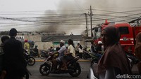 Warga menyaksikan kebakaran yang terjadi di gudang wallpaper di Muara Baru, Jakarta Utara.  