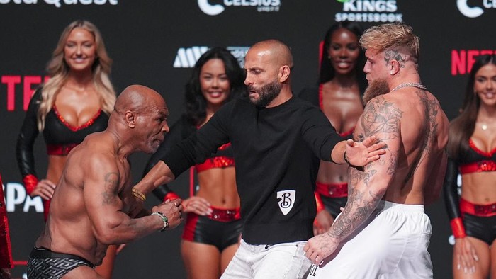 Promoter Nakisa Bidarian, center, co-founder of Most Valuable Promotions, steps in the way of Mike Tyson, left, after Tyson slapped Jake Paul during a weigh-in ahead of their heavyweight bout, Thursday, Nov. 14, 2024, in Irving, Texas. (AP Photo/Julio Cortez)