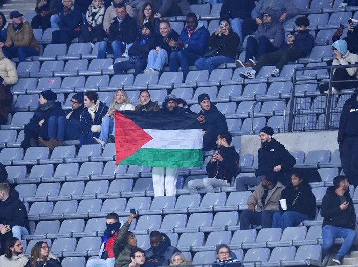 PARIS, FRANCE - NOVEMBER 14: A fan holds a Palestine flag during the UEFA Nations League 2024/25 League A Group A2 match between France and Israel at Stade de France on November 14, 2024 in Paris, France. (Photo by Franco Arland/Getty Images)