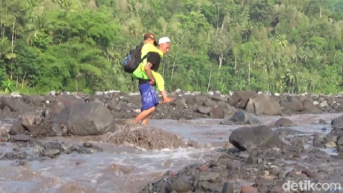Warga gendong anaknya ke sekolah menyeberangi derasnya lahar dingin Semeru
