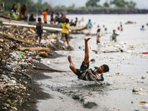 Anak-anak Berenang di Pantai Kalumata Ternate yang Tercemar Sampah